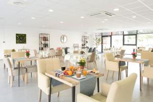 - un restaurant avec des tables et des chaises et des fruits dans l'établissement Zenao Appart'hôtels Mulhouse, à Mulhouse