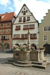 un edificio con una fuente frente a un edificio en Historik Hotel Gotisches Haus garni, en Rothenburg ob der Tauber