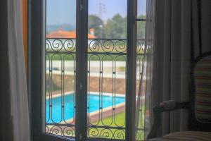 uma vista para uma piscina a partir de uma janela em Quinta da Aldeia de Avanca em Avanca