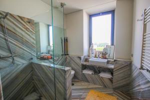 uma casa de banho com uma cabina de duche em vidro e um lavatório. em Quinta da Aldeia de Avanca em Avanca