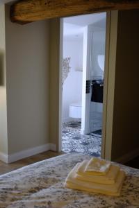 a pair of towels sitting on top of a bed at La maison du sculpteur à Tiffauges proche Puy du F in Tiffauges