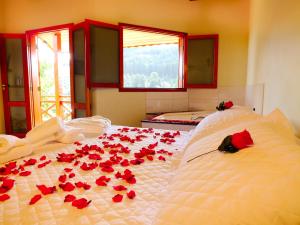 a bedroom with red roses on a bed at Pousada Vista da Serra Monte Verde in Monte Verde