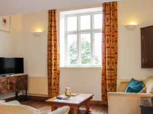 a living room with a couch and a window at Graig Gwyn Cottage in Oswestry