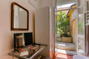 a living room with a tv and a glass table at Glamorgan in Antibes
