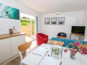 a living room with a couch and a table at 5 Yarmouth Cottages in Freshwater