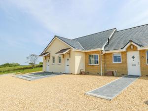 a house with a gravel driveway in front of it at 5 Yarmouth Cottages in Freshwater