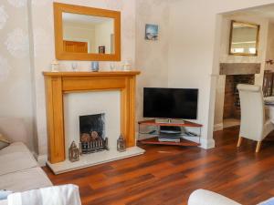 a living room with a television and a fireplace at Penrhyn View in Colwyn Bay