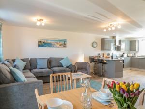 una sala de estar con un sofá y una mesa en Sea Dreams, en Marazion