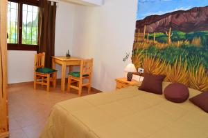 1 dormitorio con 1 cama y una pintura en la pared en El Relax en Salta