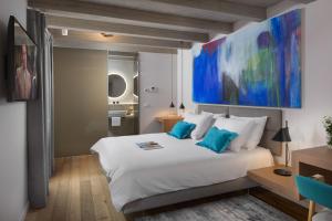 sypialnia z dużym białym łóżkiem i niebieskimi poduszkami w obiekcie Luxury Town House Corto Bechera w mieście Bale