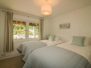 two beds in a bedroom with a window at Kittiwake in Plymouth
