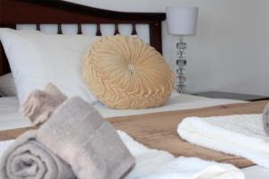 Bett mit Kissen und Handtüchern darauf in der Unterkunft The Muize in Muizenberg