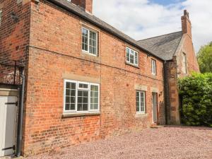 an old red brick building with white windows at Well House Farm Flat 1 in Chester