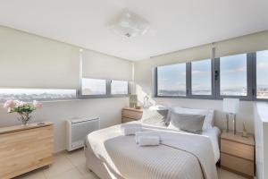 1 dormitorio con cama blanca y ventanas en GB Athens View Luxury Suite en Athens