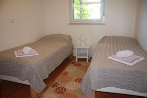 2 Betten in einem Zimmer mit Handtüchern und einem Fenster in der Unterkunft Apartman Antonia in Poreč