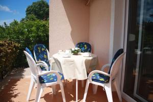 ein Tisch mit blau-weißen Stühlen und ein Tisch mit einer weißen Tischdecke in der Unterkunft Apartman Antonia in Poreč + 32 Fotos