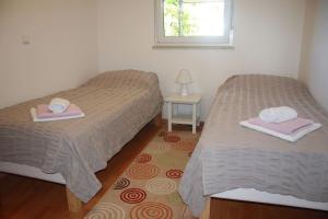 2 Betten in einem Zimmer mit Handtüchern und einem Fenster in der Unterkunft Apartman Antonia in Poreč