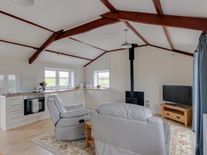 a living room with white furniture and a tv at Village View in Bridport