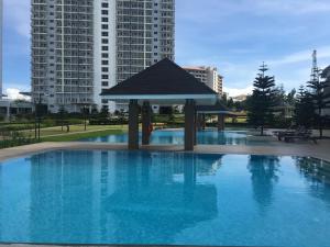 a large swimming pool with a gazebo in front of buildings at Heaven Suites, Tagaytay Condominium, Wind Residences in Tagaytay