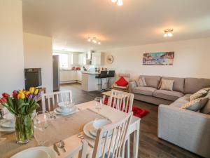 Una cocina y una sala de estar con una mesa y un sofá. en Ocean Breeze, en Marazion 21 fotos más