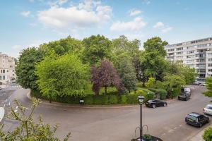 a park with trees and cars on a city street at Hyde Park Residence in London