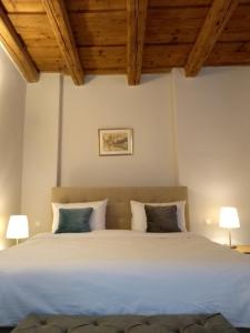 a bedroom with a large white bed with two lamps at May House Rodinný Historický dom in Modra +10 photos