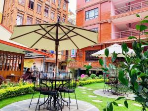 a table and chairs with an umbrella in a courtyard at Kathmandu Garden Home in Kathmandu