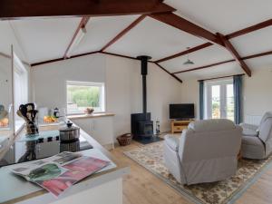 a living room with white walls and wooden beams at Village View in Bridport