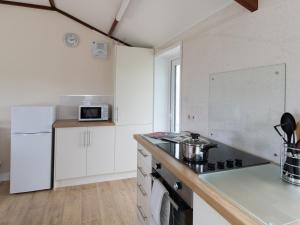 a kitchen with white cabinets and a stove top oven at Village View in Bridport