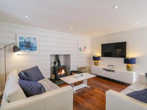 a living room with a couch and a fireplace at 36 Sandend Village in Banff