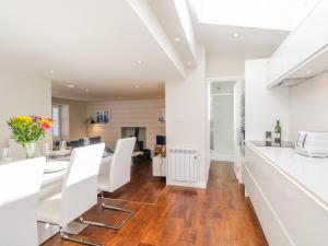 a kitchen and dining room with white walls and wood floors at 36 Sandend Village in Banff