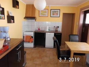 a kitchen with a table and a kitchen with a stove at ostseenahe Gartenidylle EG in Ribnitz-Damgarten