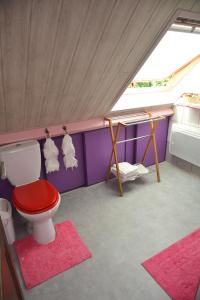 uma casa de banho com um WC vermelho e um lavatório. em Le Calme De la Campagne au Sud de Paris em Saint-Mammès