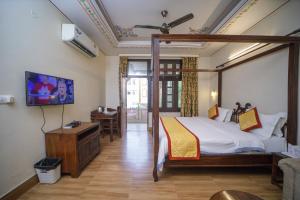 a bedroom with a bed and a tv in a room at Hotel H R Palace in Jaipur