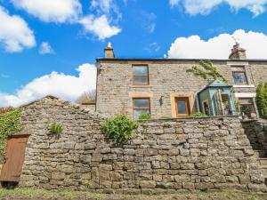 a stone wall in front of a house at 2 Holme Pool in Bishop Auckland