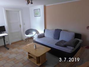 a living room with a blue couch and a table at ostseenahe Gartenidylle EG in Ribnitz-Damgarten