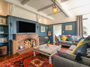 a living room with a fireplace and a tv at The Coach House in Teignmouth