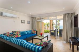 a living room with a blue couch and a table at Ballito Manor - Manor View 102 in Ballito