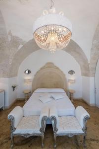 a bedroom with a bed and a chandelier at Palazzo Gallo Resort in Gallipoli