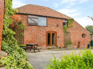 una casa in mattoni con un tavolo da picnic di fronte di Barn Owl a Louth