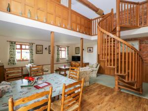 ein Wohnzimmer mit einem Tisch und einer Treppe in der Unterkunft Barn Owl in Louth