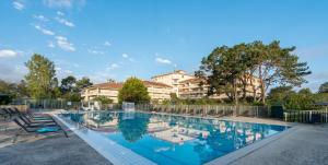 a swimming pool in front of a building at Hôtel et Résidence de Chiberta et du Golf in Anglet