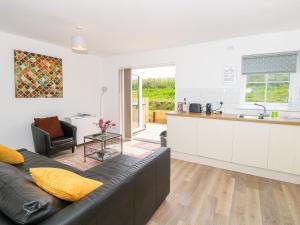 uma sala de estar com um sofá e uma cozinha em 6 Yarmouth Cottages em Freshwater