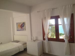 ein Schlafzimmer mit einem Bett und einem Fenster in der Unterkunft ZEN PLACE in Kouniádhoi