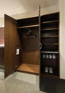 a walk in closet with a wooden door at HOTEL PROMOTE HIROSHIMA in Hiroshima