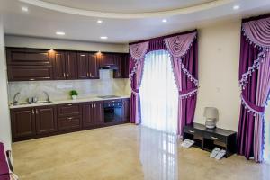 a kitchen with purple curtains and a sink at Palace in Uman