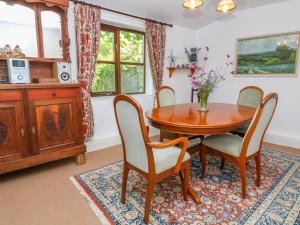 彭贊斯的住宿－The Thatched Cottage，一间带木桌和椅子的用餐室