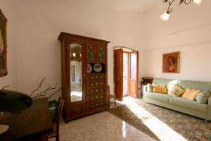 ein Wohnzimmer mit einem Sofa und einem Schrank in der Unterkunft ALLOGGIO CASA IN PIETRA in Santu Lussurgiu