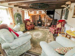 een woonkamer met een bank en stoelen en een open haard bij Old Stables Cottage in Saltburn-by-the-Sea