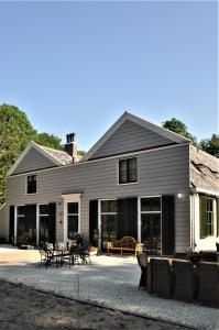 a large house with glass doors and a patio at Gasterij Leyduin in Vogelenzang